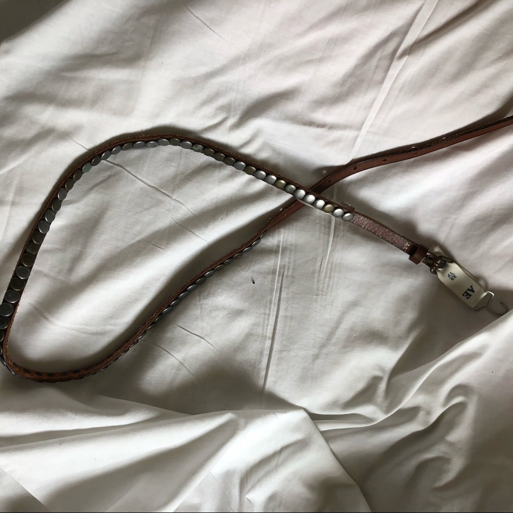 Thin brown belt with metal circles on it